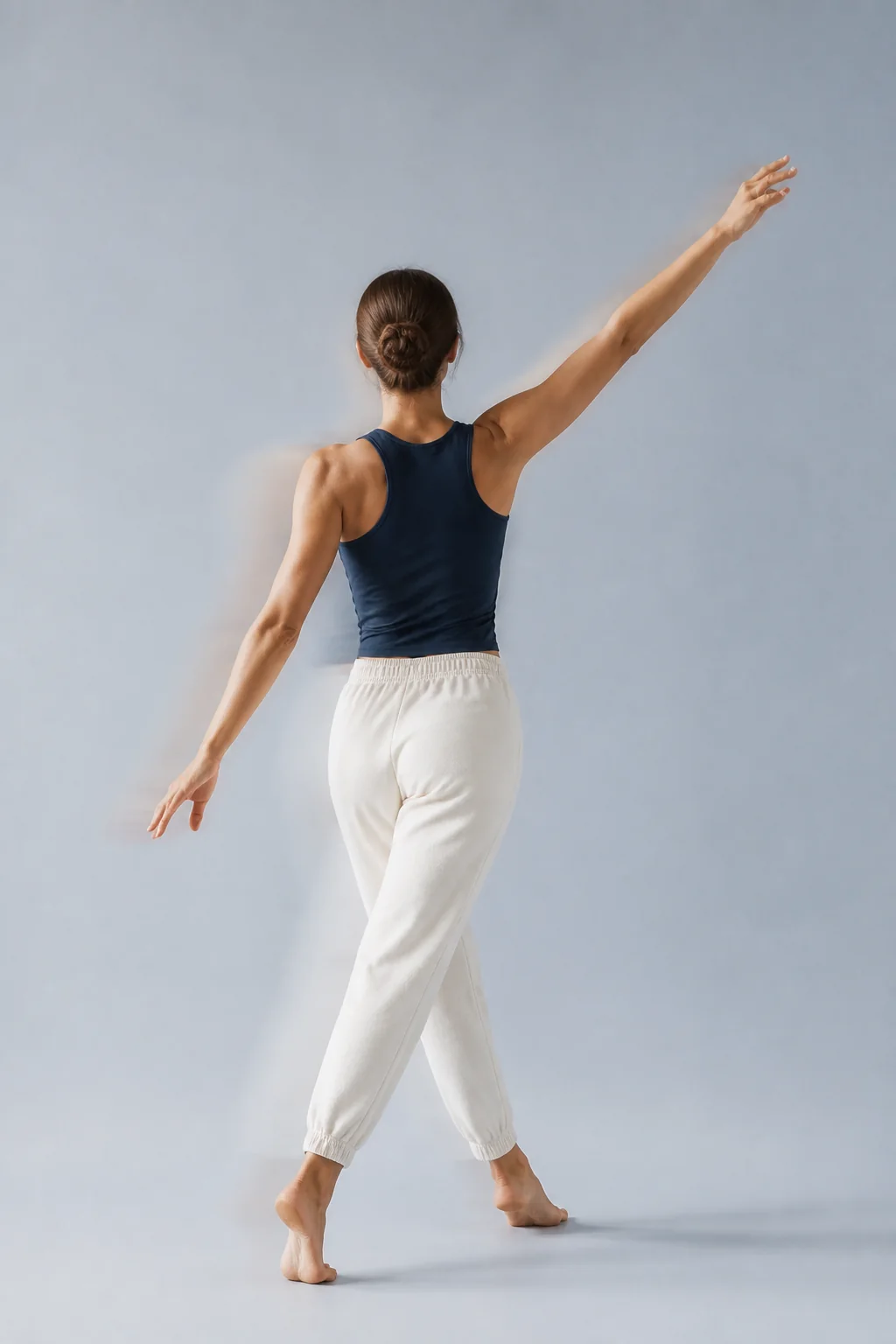 A back-facing person moving confidently in a light-filled studio
